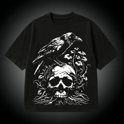 Black t-shirt with a white graphic of a raven on a skull and flowers on a dark background